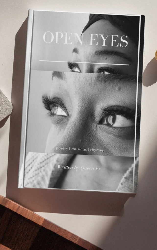 A book called Open Eyes by Queen Ex on a desk